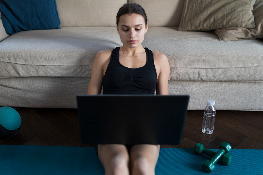 Laptop showing a sports statistics screen beside a water bottle